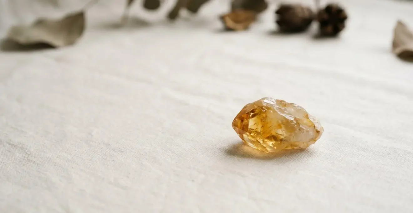 Scène minimaliste montrant une pierre de citrine isolée dans un espace épuré symbolisant la clarté énergétique