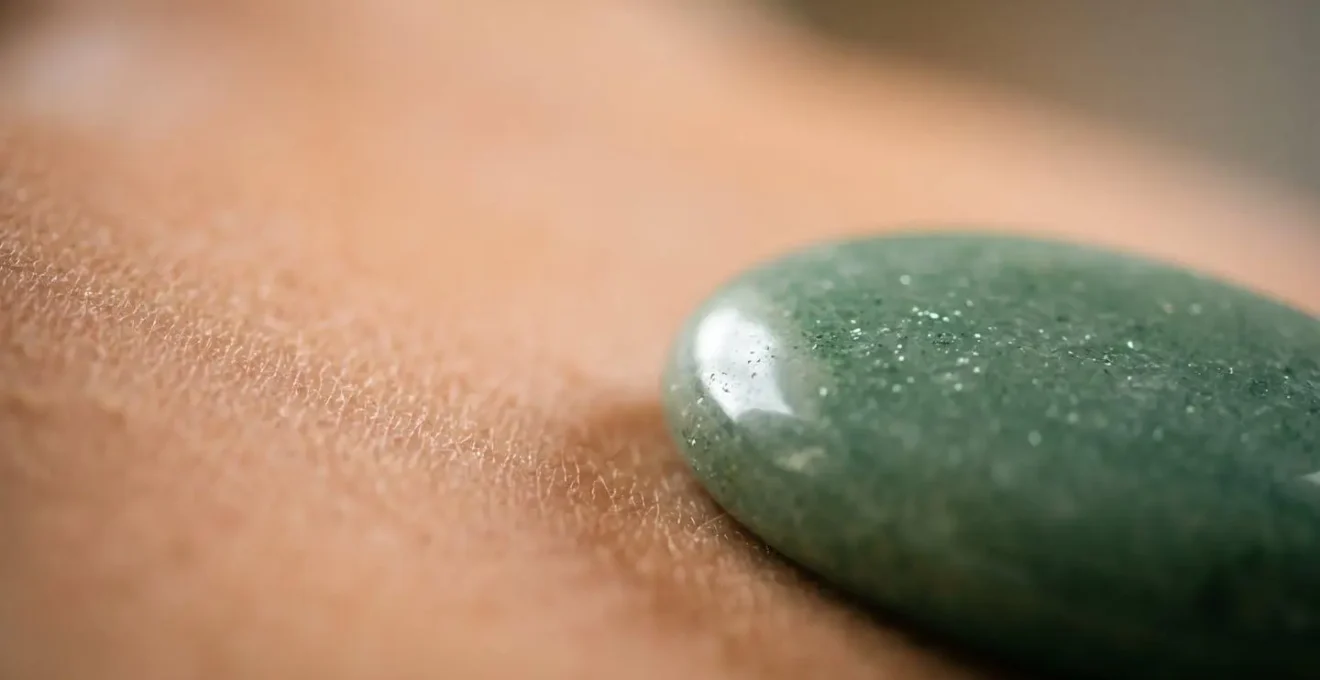 Vue macro détaillée d'un galet d'aventurine posé sur le sternum pour libérer l'oppression thoracique