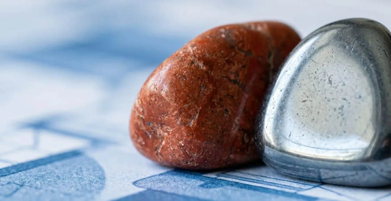 Gros plan sur des pierres de jaspe rouge et hématite disposées sur des plans architecturaux