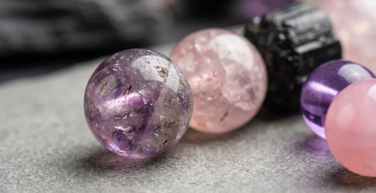 Gros plan macro sur des perles de pierres naturelles révélant les inclusions et imperfections caractéristiques de leur authenticité